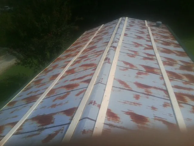 Rusted metal roof panels with new wood purlins before replacement — Storm Damage Roof Repair in Jamaica by Roofing Brothers