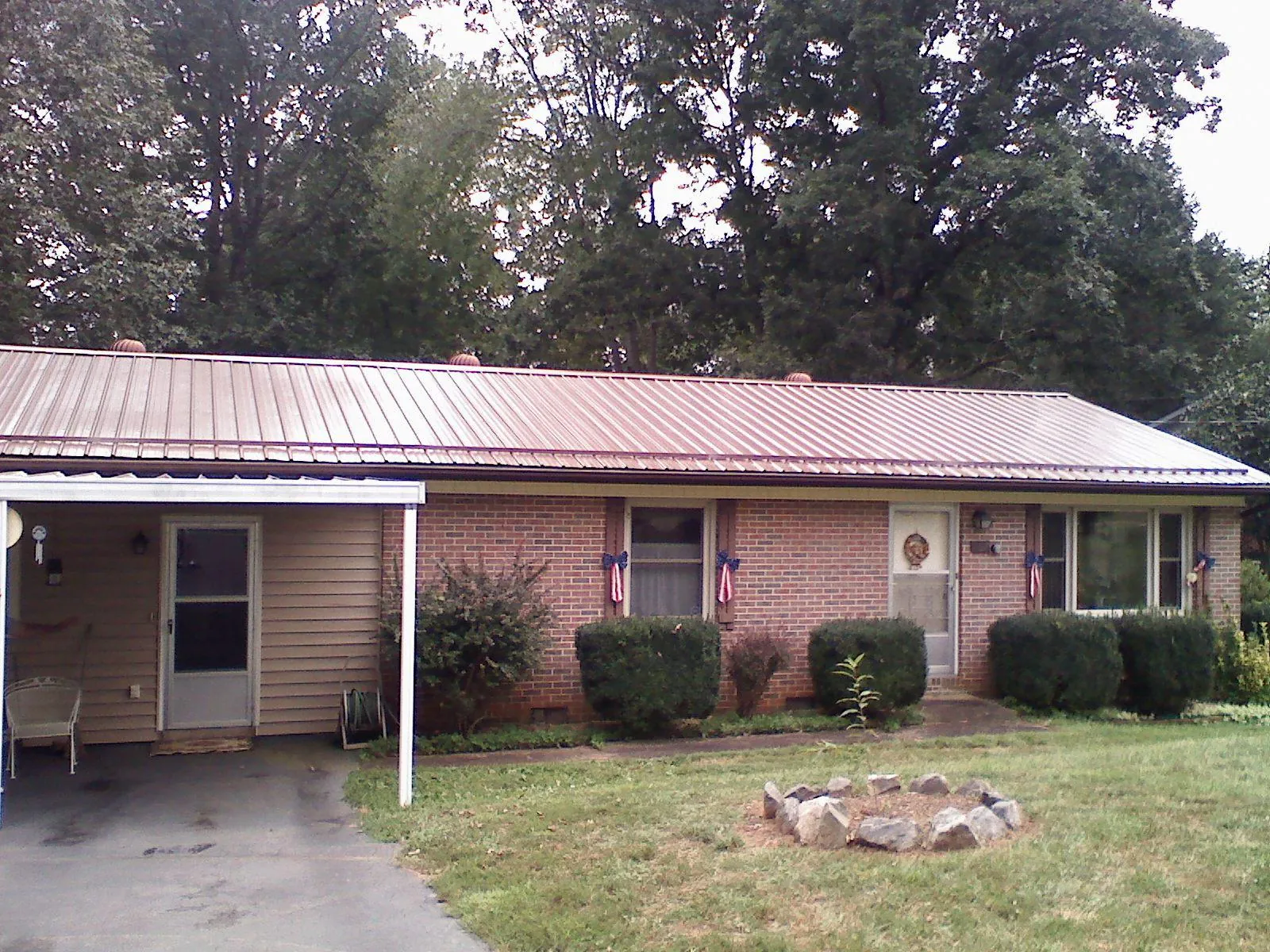 Bronze metal roof and carport on a brick ranch home — Roof Repair work by our crew in Jamaica